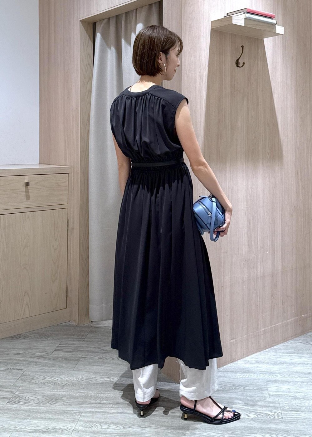 ブラック系のサンダル、ホワイト系のスラックス、ブラック系のワンピースを着用したレディースの夏コーディネートの4枚目の写真