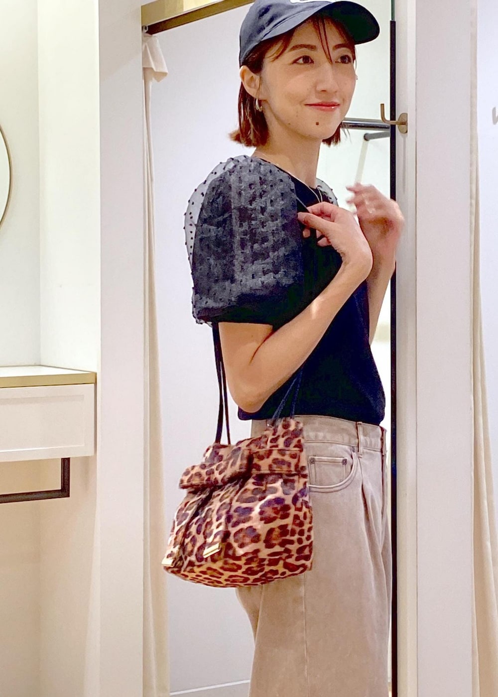 ブラック系のローファー、ブラック系のニット/セーター、ブラウン系のデニムパンツを着用したレディースの夏コーディネートの6枚目の写真