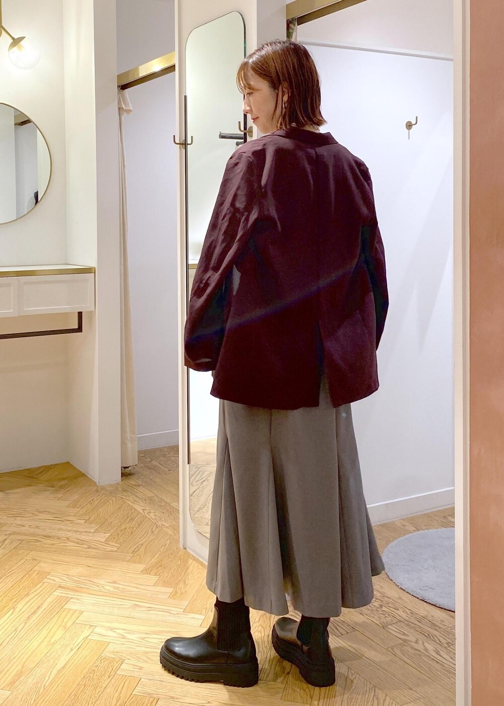 ブラック系のキャミソール、その他のショルダーバッグ、ブラック系のブーツを着用したレディースの秋コーディネートの10枚目の写真