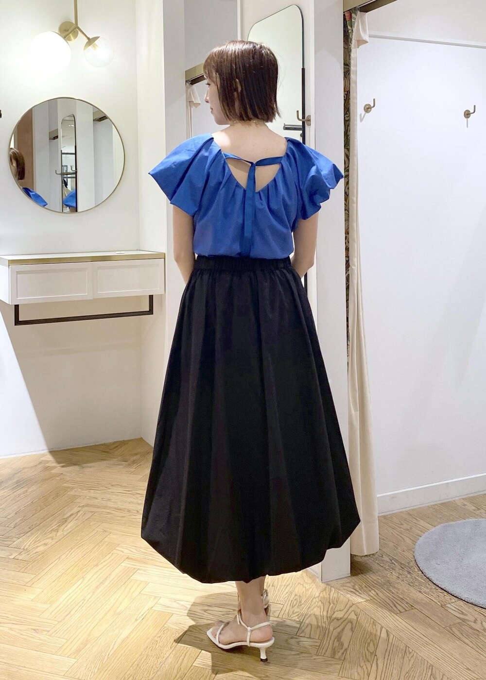 ブラック系のキャミソール、ホワイト系のサンダル、ブラック系のスカートを着用したレディースの春コーディネートの2枚目の写真