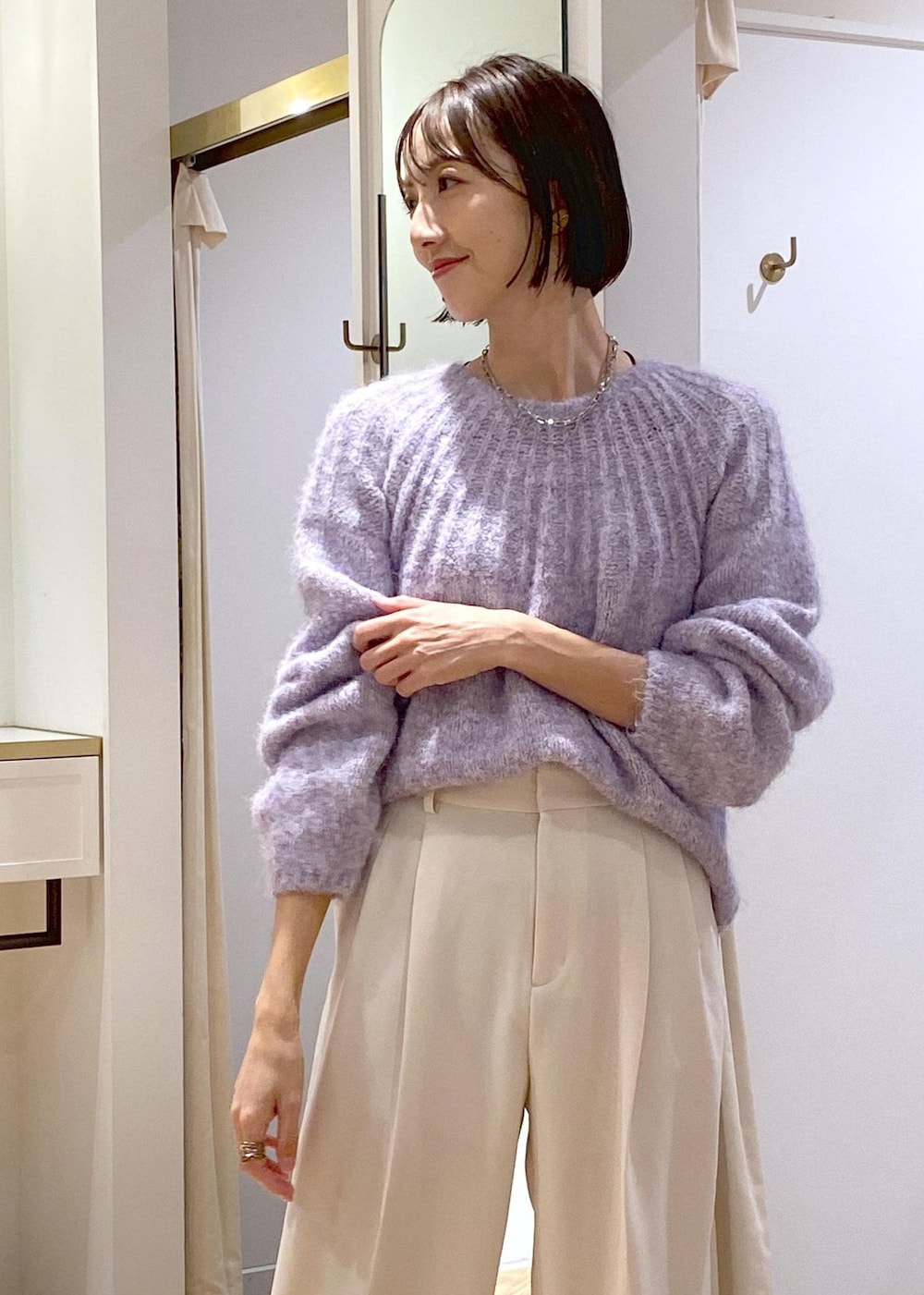 ホワイト系のブーツ、ブラック系のショルダーバッグ、パープル系のニット/セーターを着用したレディースの冬コーディネートの6枚目の写真