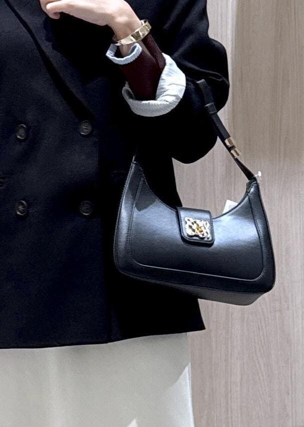 ブラック系のショルダーバッグ、ブラック系のテーラードジャケット、ブラック系のブーツを着用したレディースの冬コーディネートの6枚目の写真