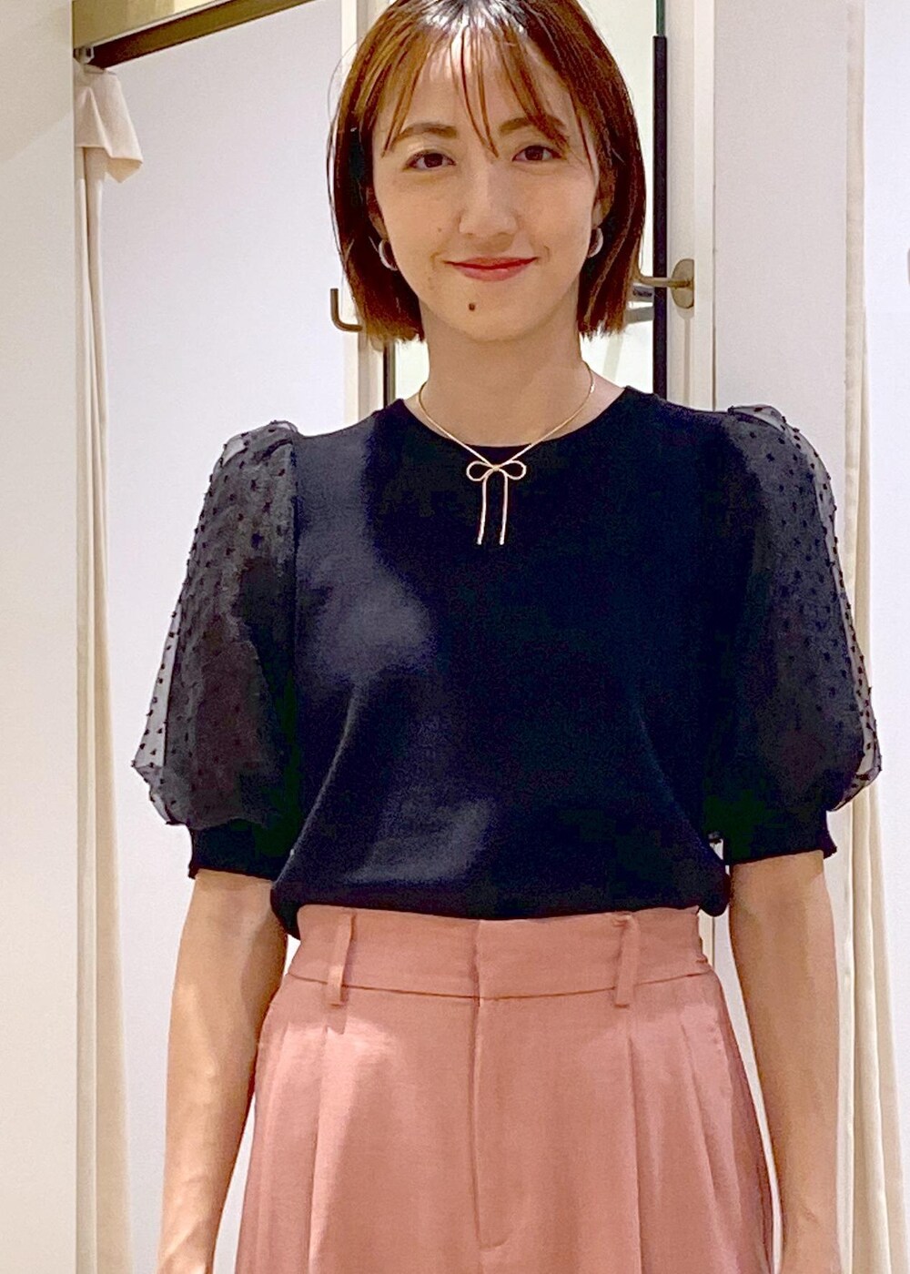 ブラック系のローファー、ブラック系のニット/セーター、ピンク系のスラックスを着用したレディースの夏コーディネートの6枚目の写真