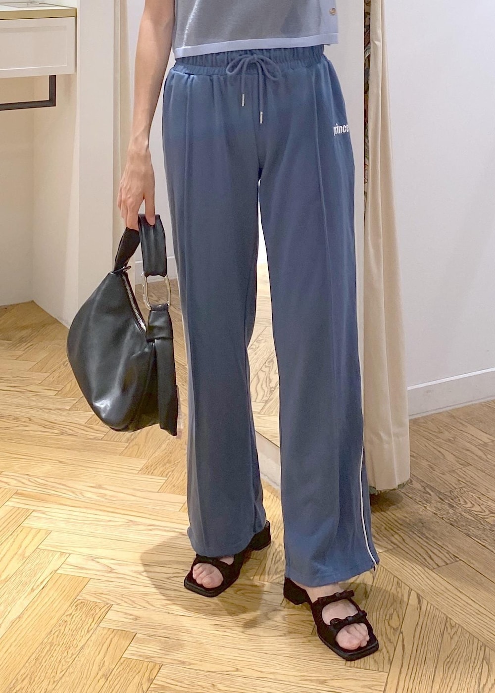 ブラック系のハンドバッグ、ブラック系のサンダル、ブラック系のキャミソールを着用したレディースの夏コーディネートの6枚目の写真