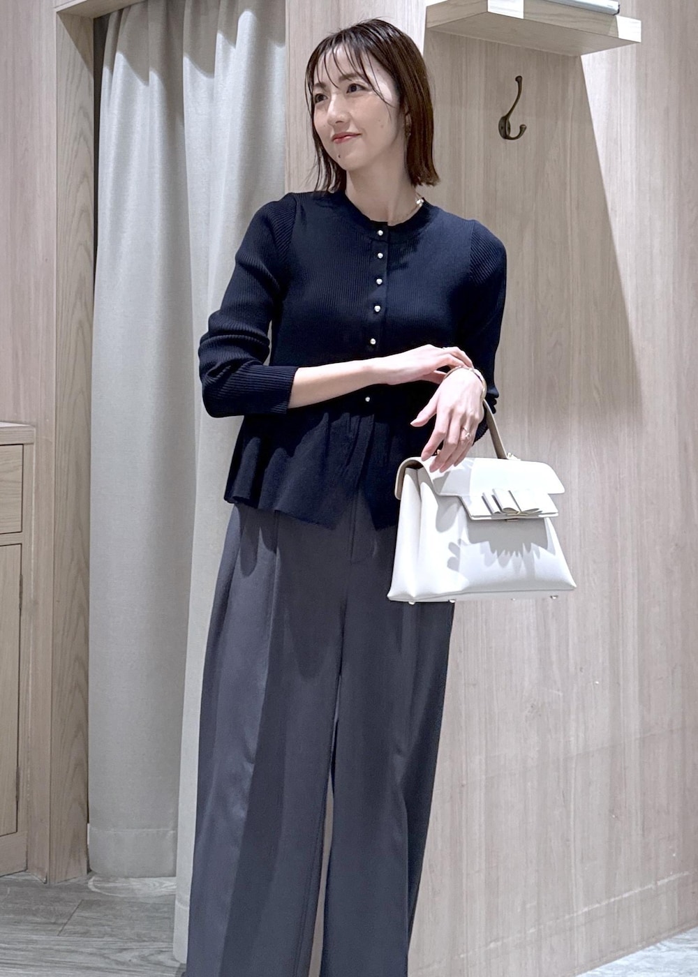 ブラック系のパンプス、グレー系のその他パンツ、ブルー系のカーディガン/ボレロを着用したレディースの冬コーディネートの2枚目の写真