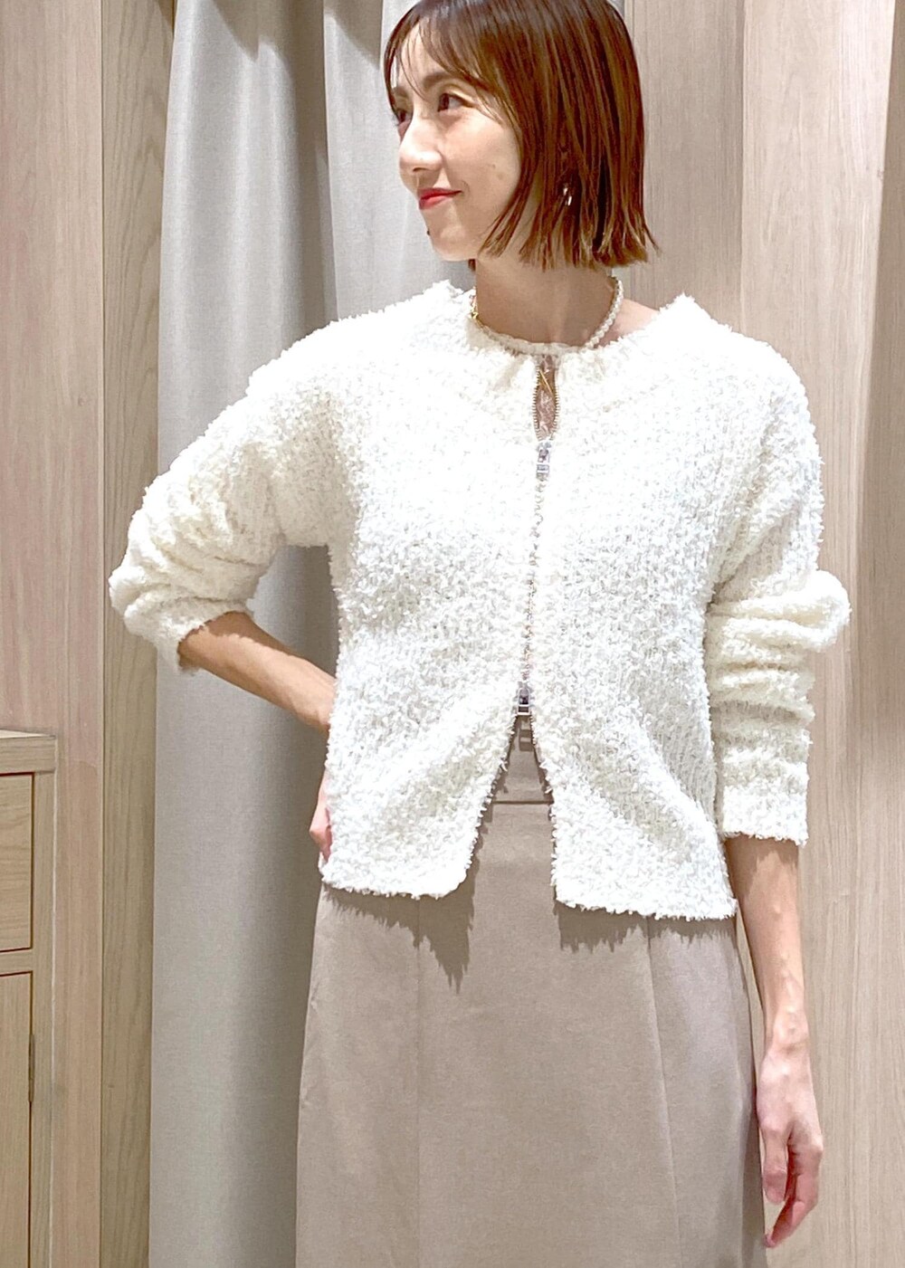 ホワイト系のブーツ、ベージュ系のスカート、ホワイト系のカーディガン/ボレロを着用したレディースの冬コーディネートの8枚目の写真