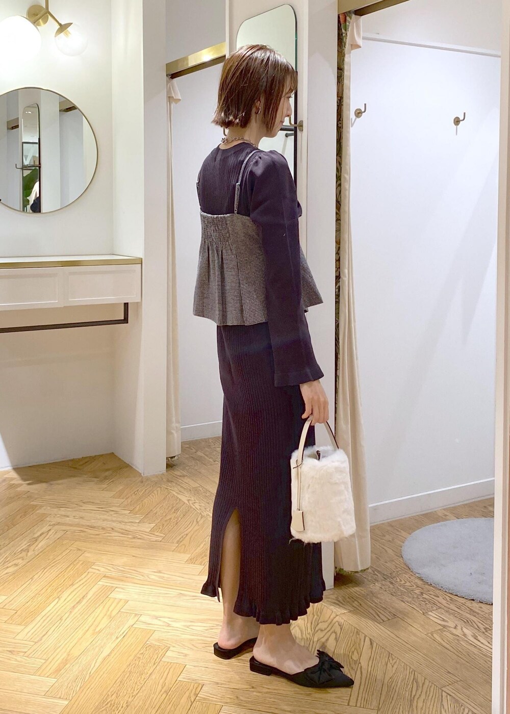 ブラック系のサンダル、ブラック系のワンピース、ホワイト系のショルダーバッグを着用したレディースの秋コーディネートの3枚目の写真