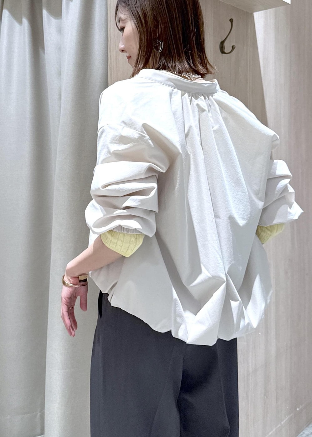 ホワイト系のパンプス、グレー系のトートバッグ、ホワイト系のブルゾンを着用したレディースの春コーディネートの5枚目の写真