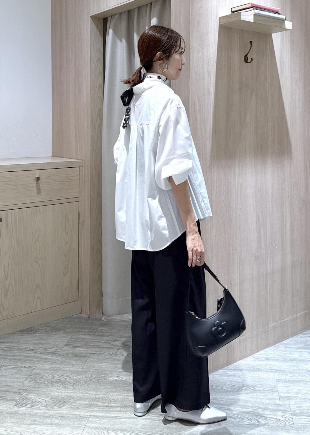 ブラック系のその他パンツ、シルバー系のパンプス、ホワイト系のシャツ/ブラウスを着用したレディースの秋コーディネートの3枚目の写真