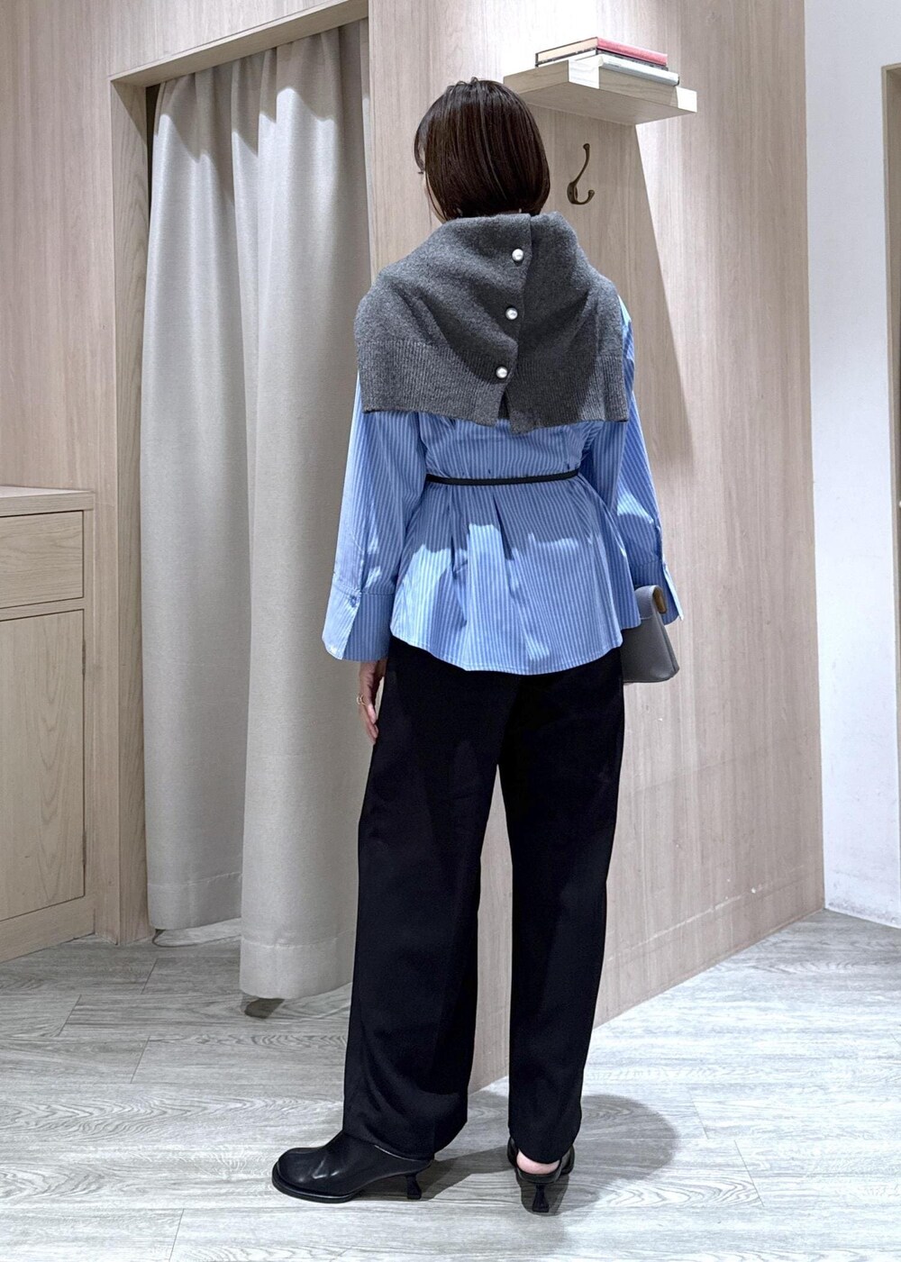 グレー系のショルダーバッグ、ブラック系のスラックス、グレー系のカーディガン/ボレロを着用したレディースの秋コーディネートの5枚目の写真