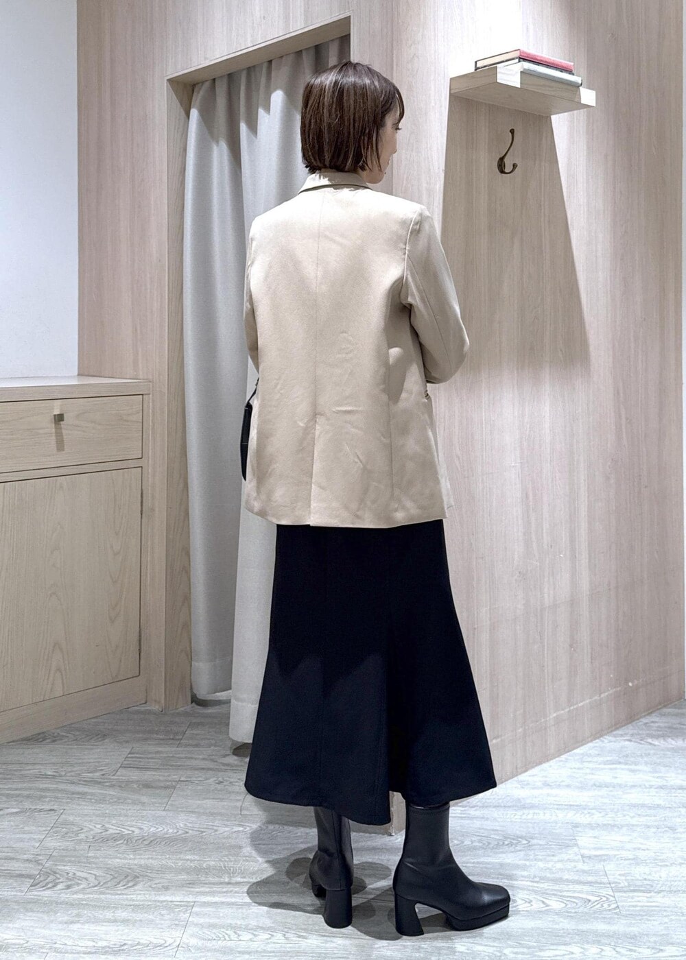 ブラック系のハンドバッグ、ブルー系のシャツ/ブラウス、ベージュ系のテーラードジャケットを着用したレディースの秋コーディネートの4枚目の写真