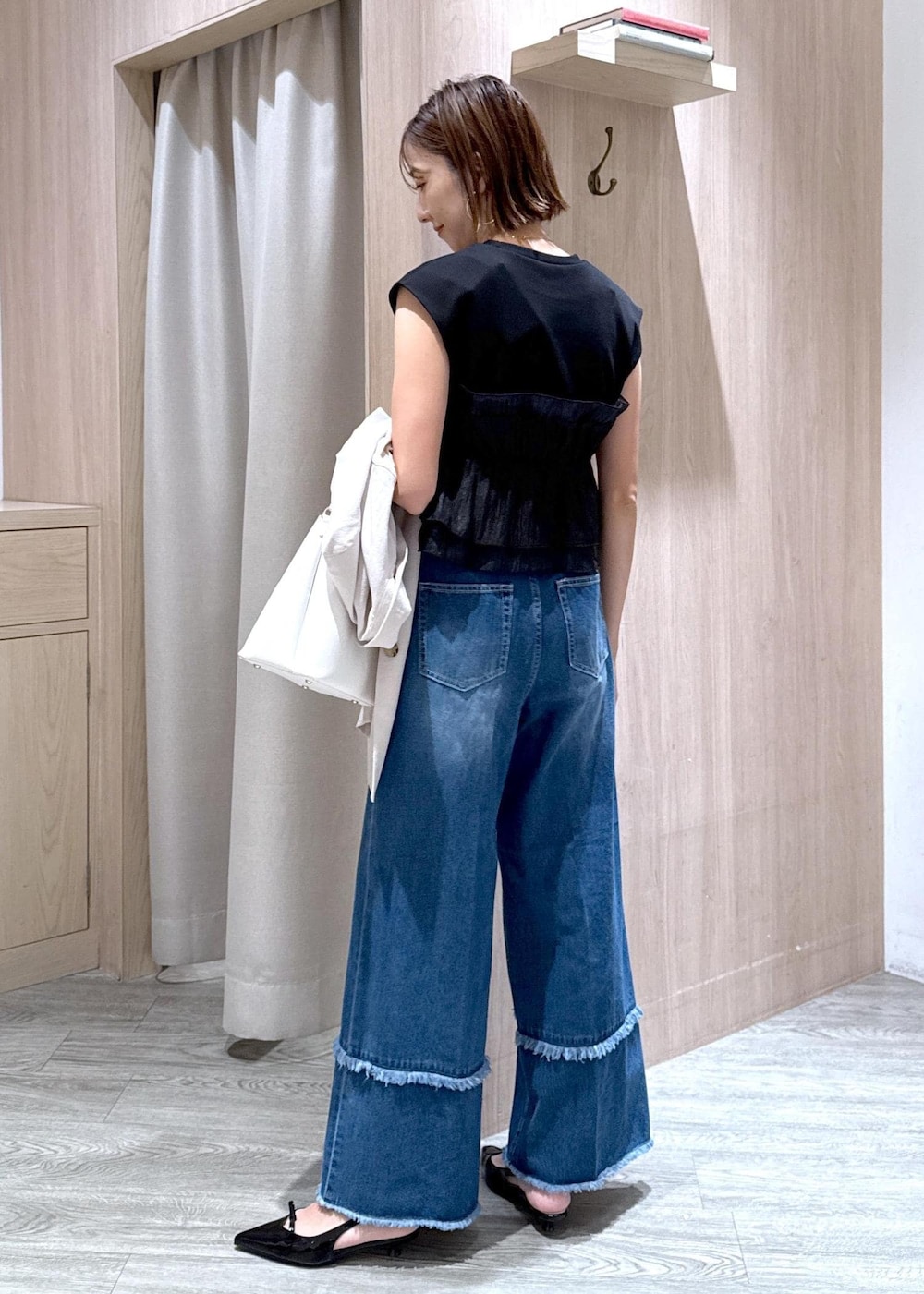 ホワイト系のショルダーバッグ、ブラック系のパンプス、ブラック系のTシャツ/カットソーを着用したレディースの夏コーディネートの3枚目の写真