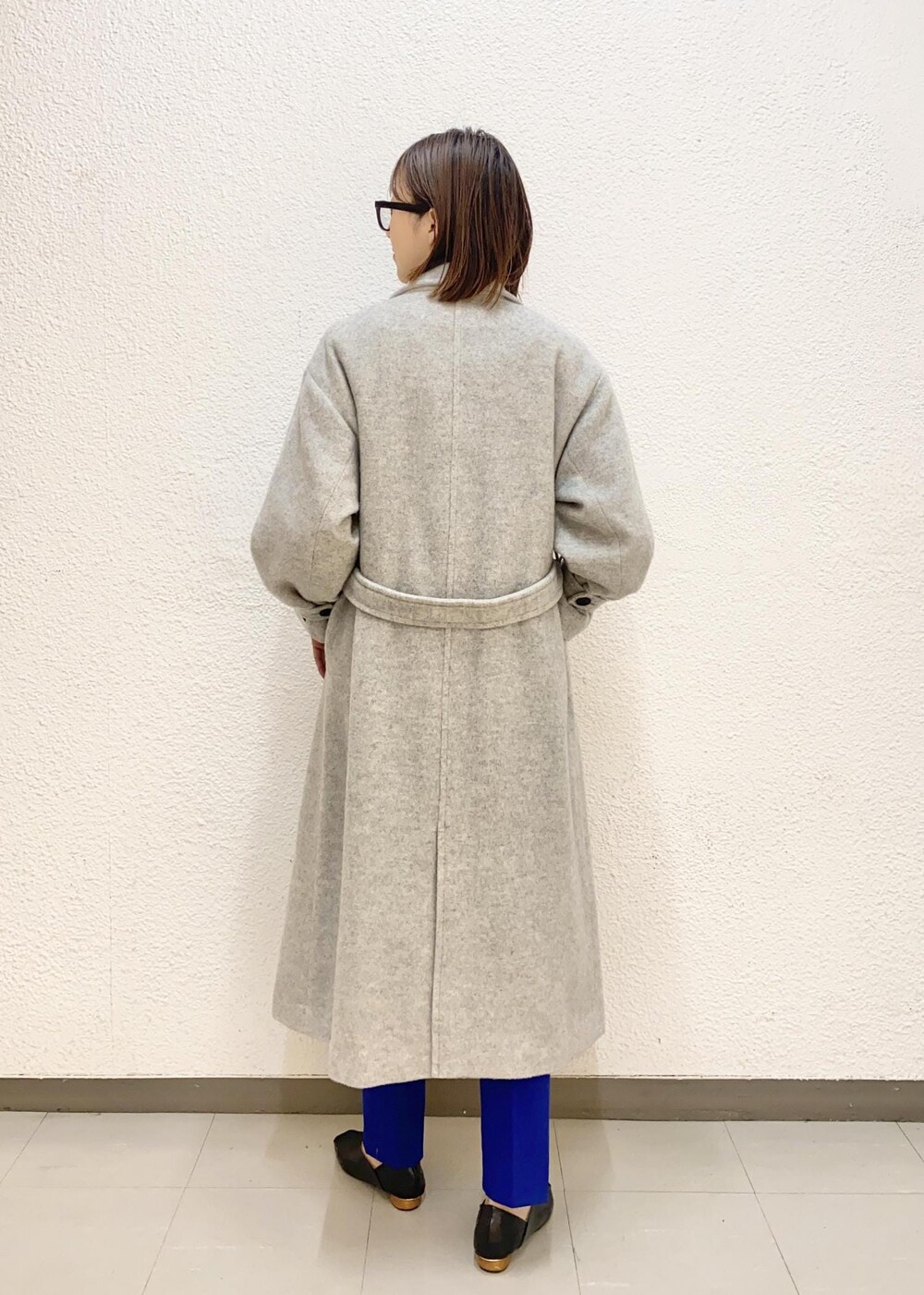 グレー系のその他アウター、ブルー系のスラックス、ブラック系のニット/セーターを着用したレディースの冬コーディネートの3枚目の写真