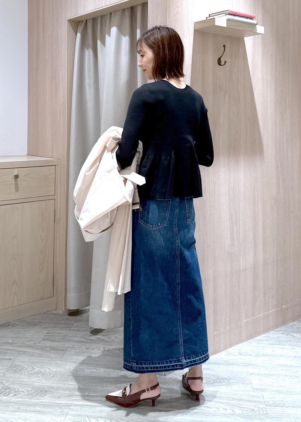 ブラック系のショルダーバッグ、ブラウン系のパンプス、ブルー系のデニムスカートを着用したレディースの春コーディネートの10枚目の写真