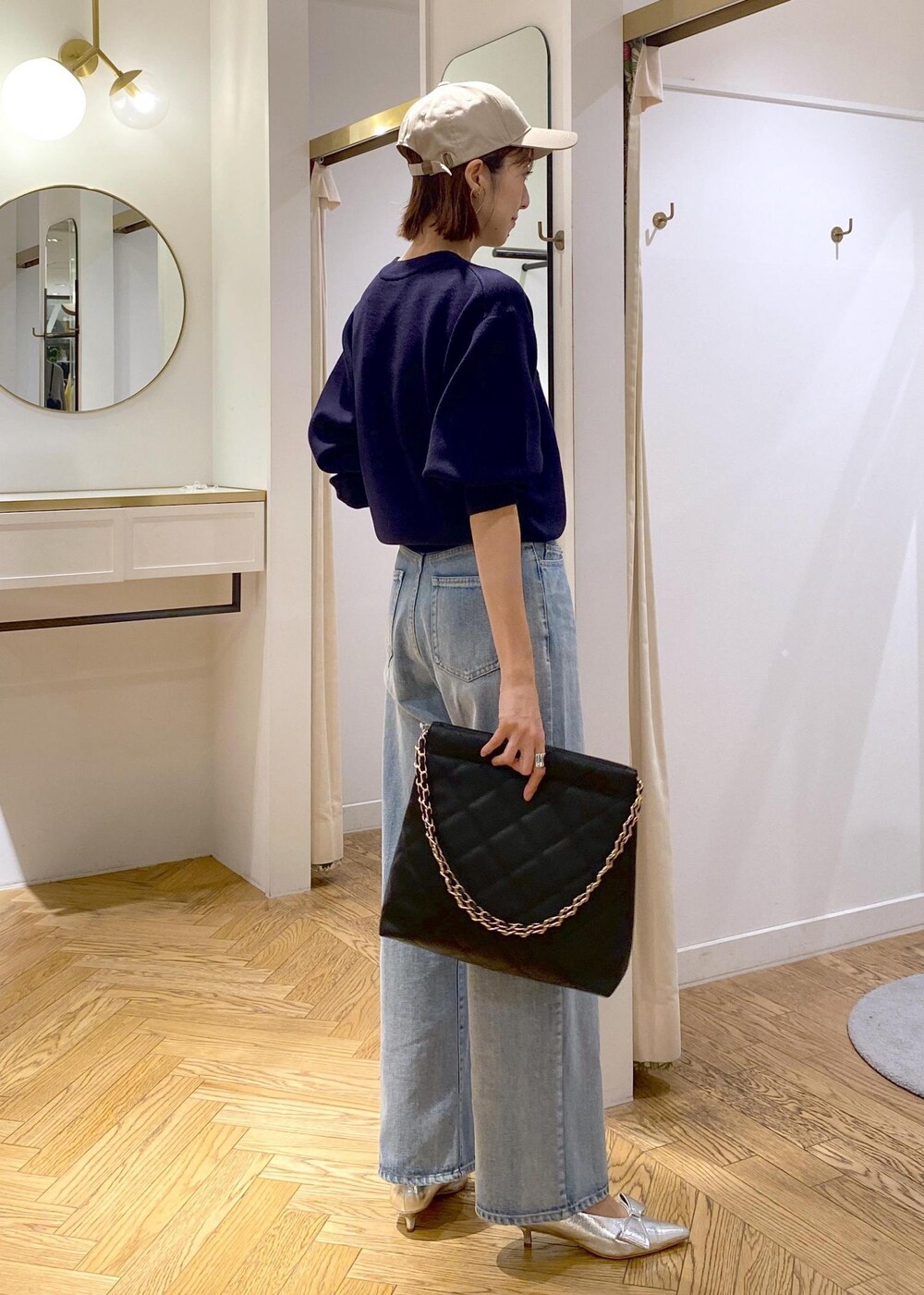 シルバー系のパンプス、ホワイト系のブルゾン、ブルー系のニット/セーターを着用したレディースの秋コーディネートの9枚目の写真