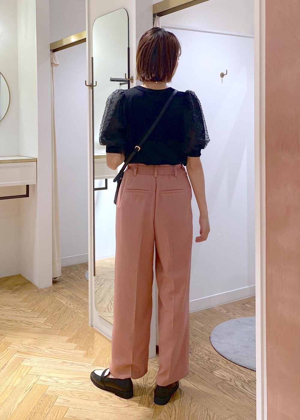 ブラック系のローファー、ブラック系のニット/セーター、ピンク系のスラックスを着用したレディースの夏コーディネートの3枚目の写真