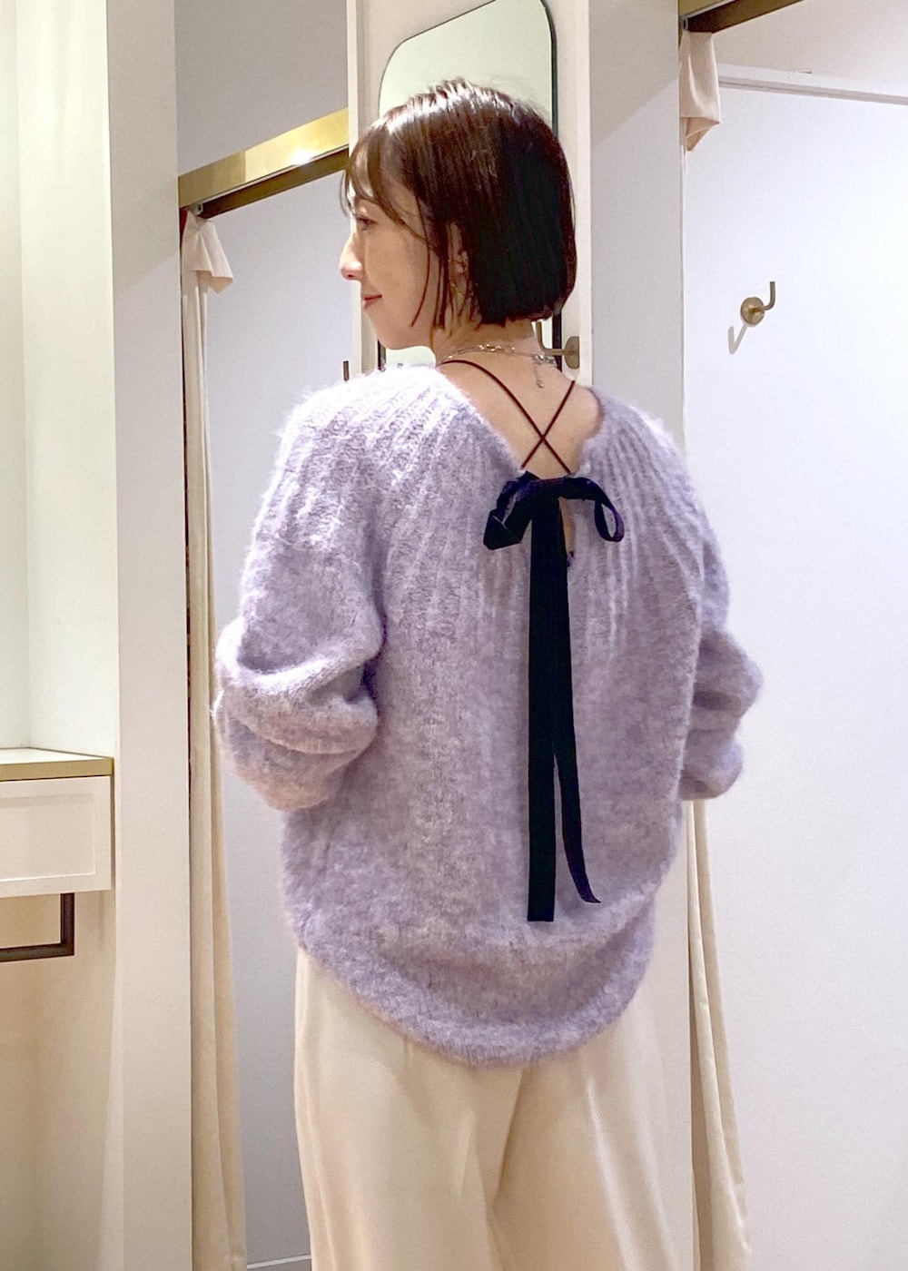 ホワイト系のブーツ、ブラック系のショルダーバッグ、パープル系のニット/セーターを着用したレディースの冬コーディネートの7枚目の写真