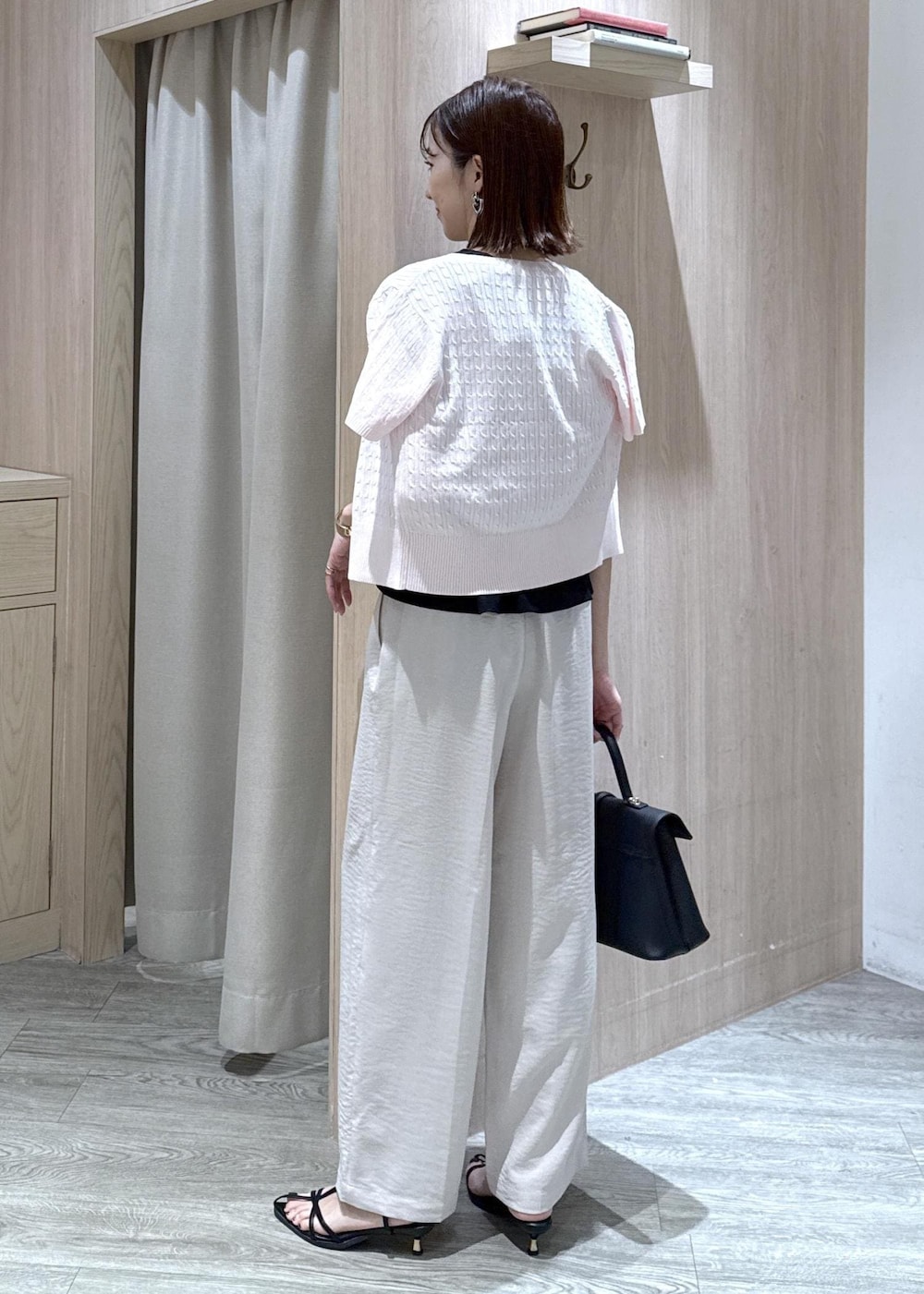 ブラック系のハンドバッグ、ホワイト系のその他パンツ、ピンク系のカーディガン/ボレロを着用したレディースの夏コーディネートの3枚目の写真