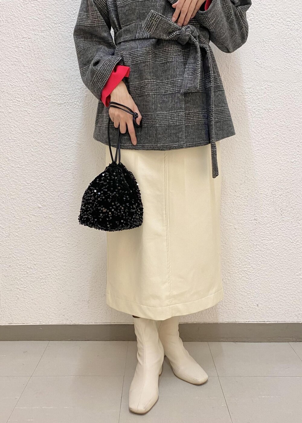 ホワイト系のスカート、ブラック系のその他アウター、ブラック系のハンドバッグを着用したレディースの冬コーディネートの4枚目の写真