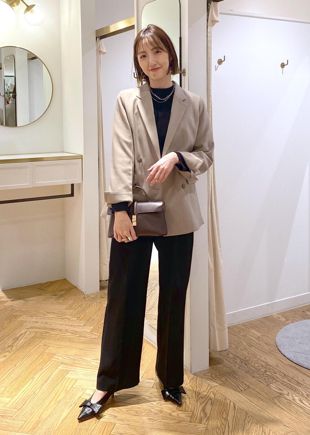 ブラック系のパンプス、ブラック系のニット/セーター、ブラック系のスラックスを着用したレディースの冬コーディネートの3枚目の写真