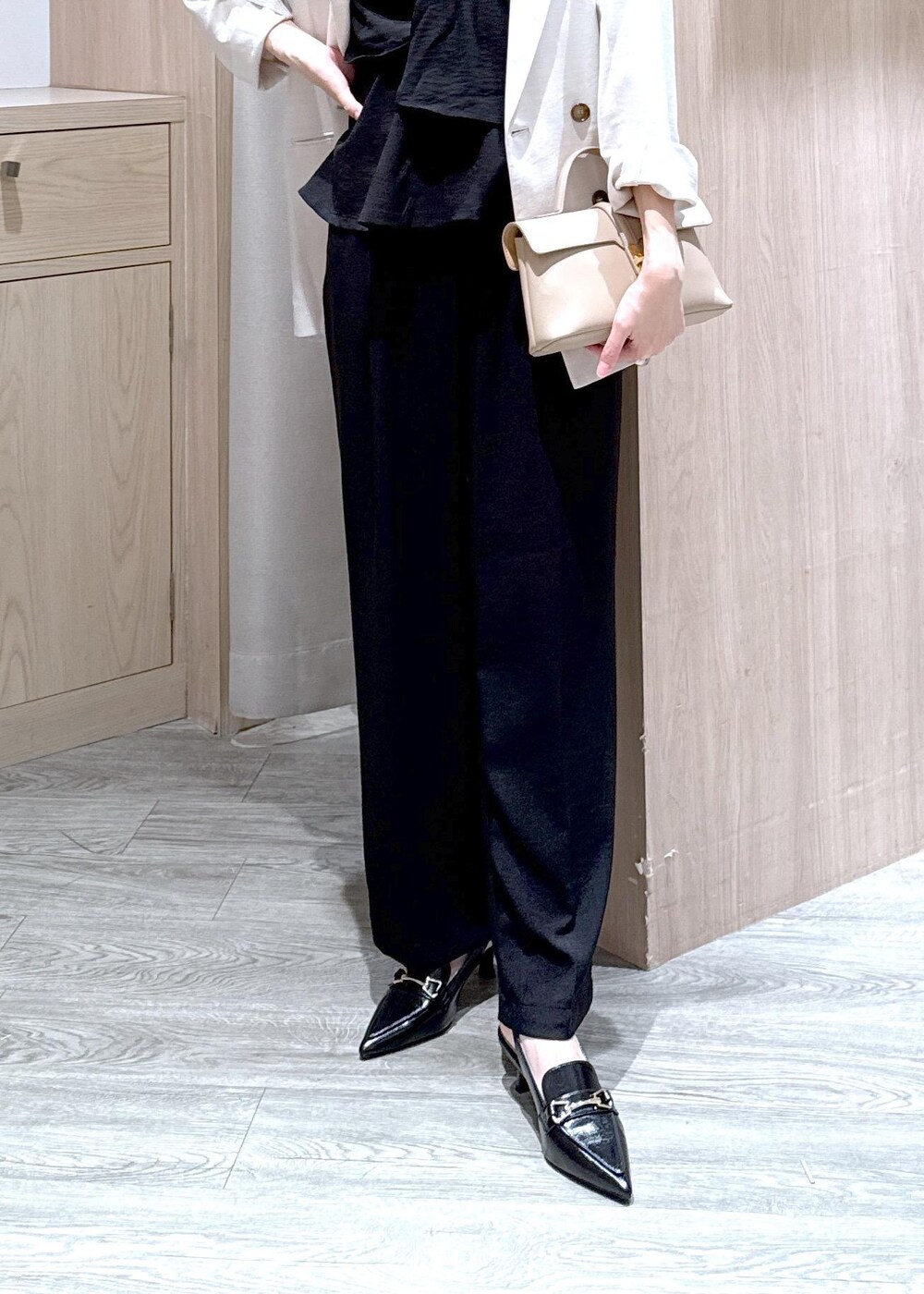 ベージュ系のショルダーバッグ、ブラック系のパンプス、ホワイト系のテーラードジャケットを着用したレディースの春コーディネートの6枚目の写真