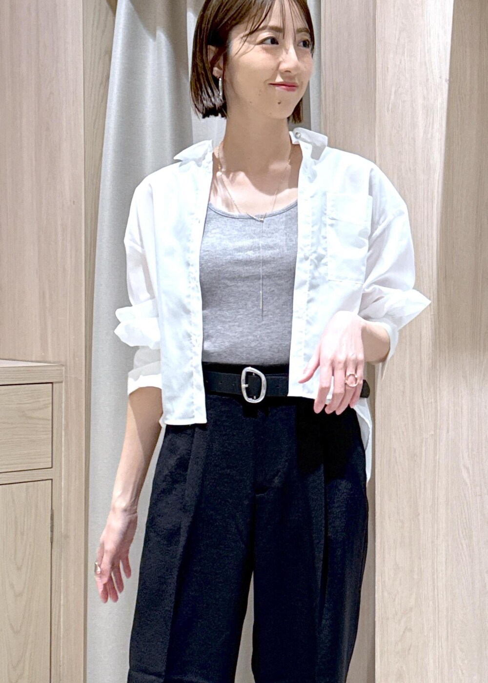 グレー系のタンクトップ、シルバー系のショルダーバッグ、ブラック系のサンダルを着用したレディースの春コーディネートの7枚目の写真