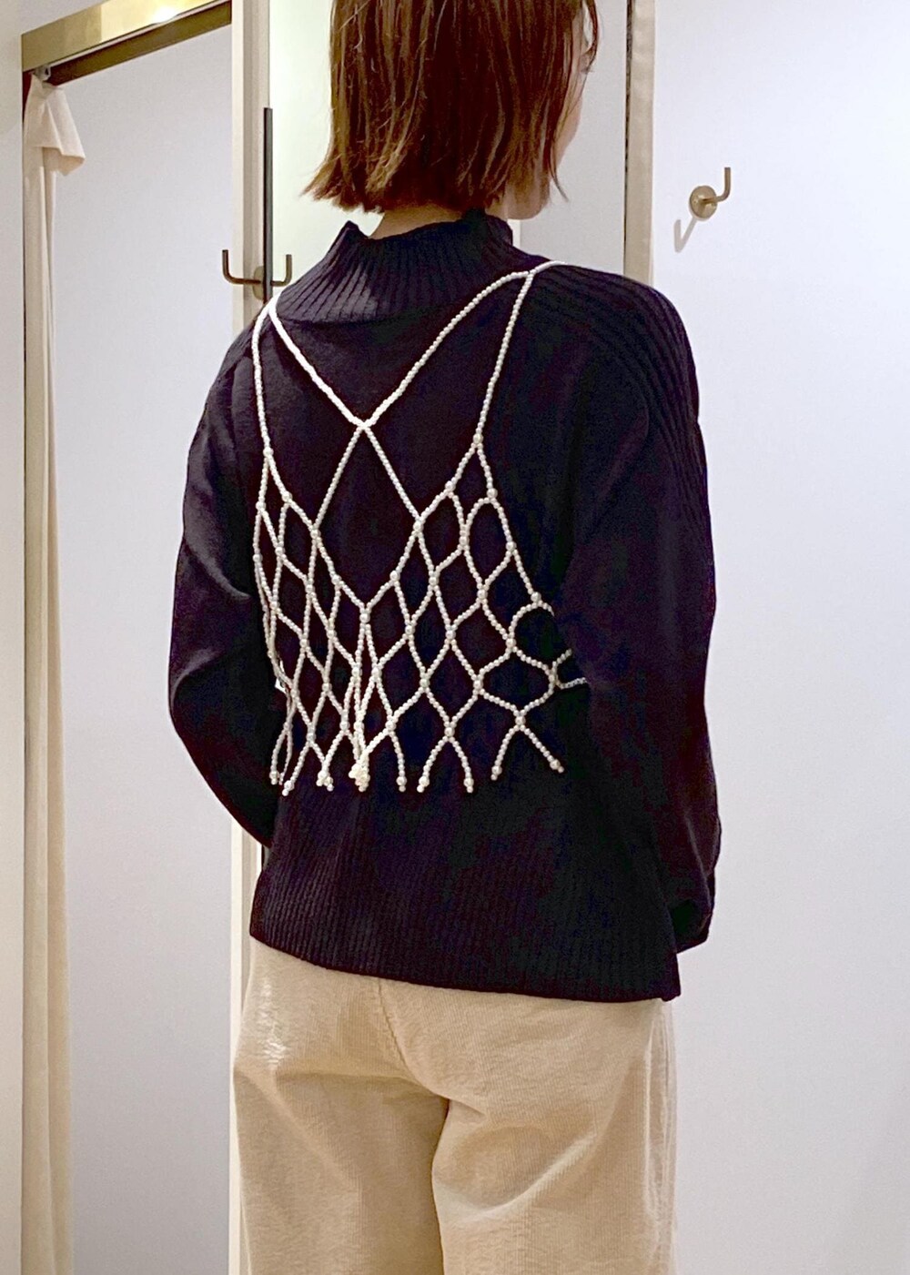 ブラック系のショルダーバッグ、ホワイト系のキャミソール、ベージュ系のスラックスを着用したレディースの秋コーディネートの7枚目の写真