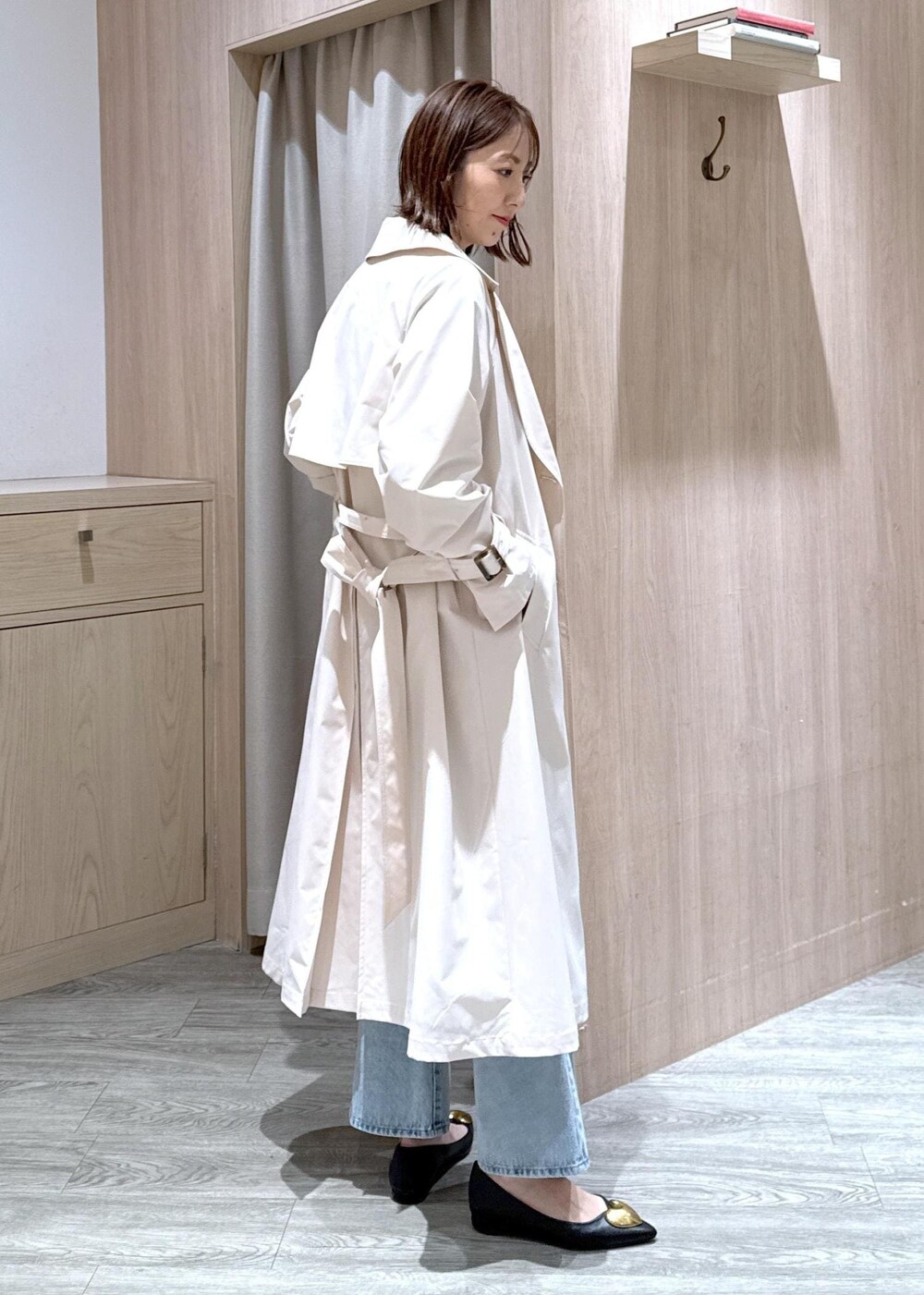 ブラック系のハンドバッグ、ブラック系のバレエシューズ、ホワイト系のトレンチコートを着用したレディースの春コーディネートの5枚目の写真
