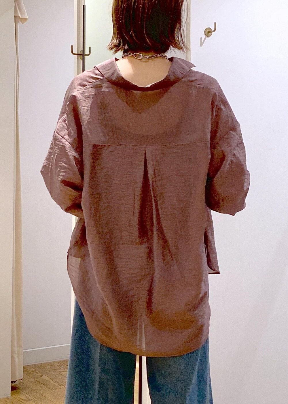 ブラック系のキャミソール、ホワイト系のショルダーバッグ、ブルー系のデニムパンツを着用したレディースの秋コーディネートの7枚目の写真