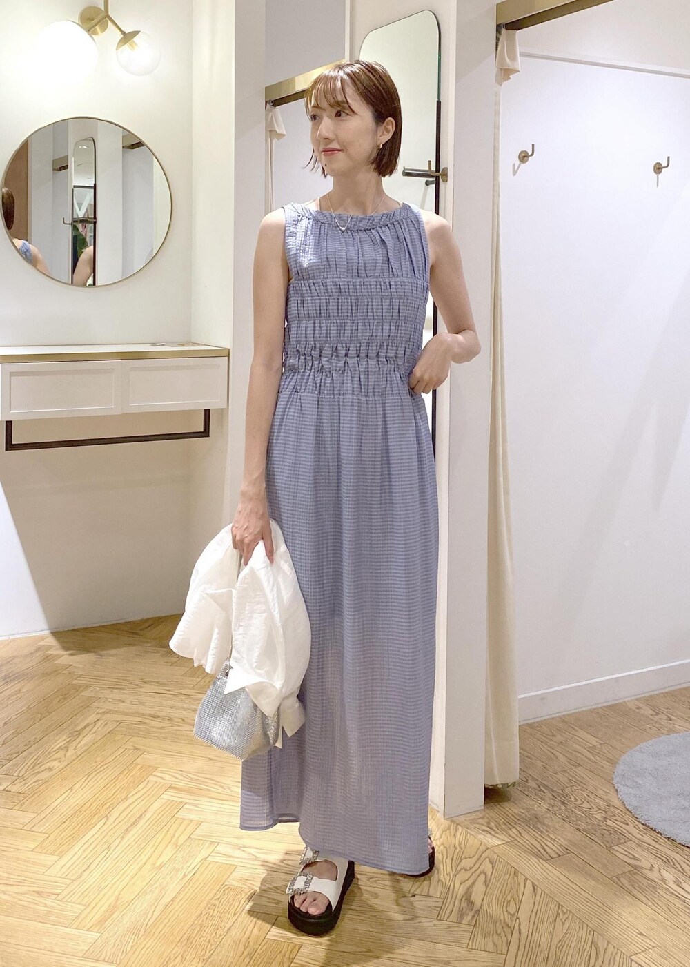 ホワイト系のサンダル、ブルー系のワンピース、シルバー系のショルダーバッグを着用したレディースの夏コーディネートの4枚目の写真