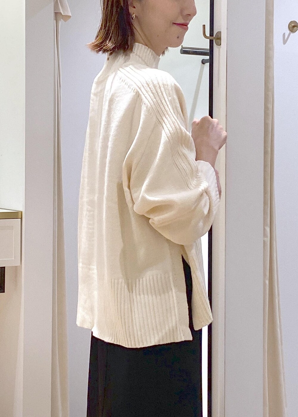 ブラック系のスカート、ホワイト系のニット/セーター、グレー系のショルダーバッグを着用したレディースの秋コーディネートの7枚目の写真