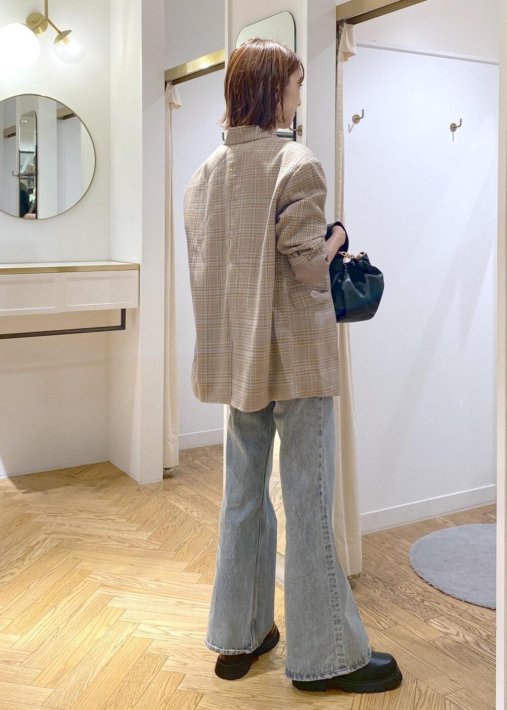 ブラック系のブーツ、ブラック系のTシャツ/カットソー、ブルー系のデニムパンツを着用したレディースの秋コーディネートの3枚目の写真