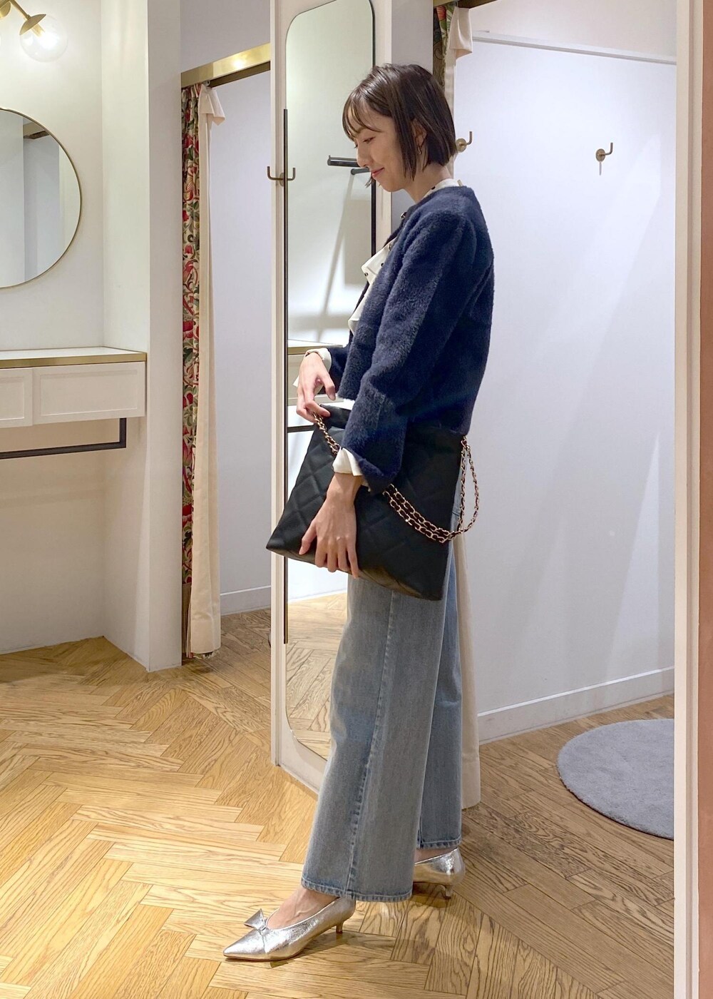 シルバー系のパンプス、ベージュ系のシャツ/ブラウス、ブルー系のカーディガン/ボレロを着用したレディースの冬コーディネートの2枚目の写真