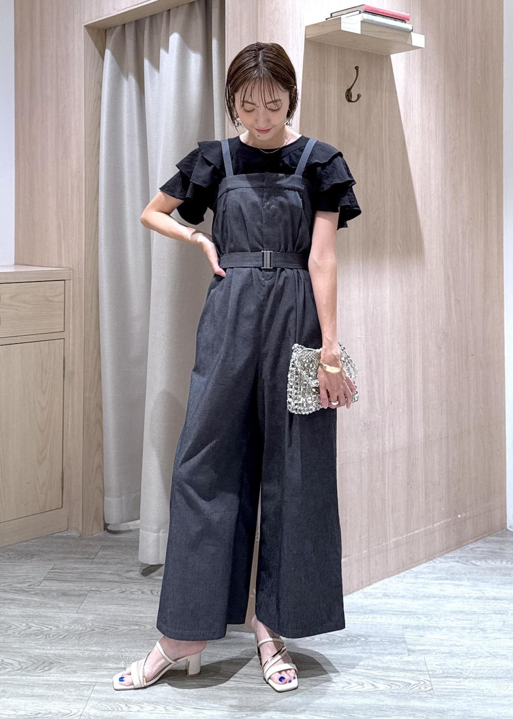 ホワイト系のサンダル、ブラック系のシャツ/ブラウス、シルバー系のハンドバッグを着用したレディースの夏コーディネートの2枚目の写真