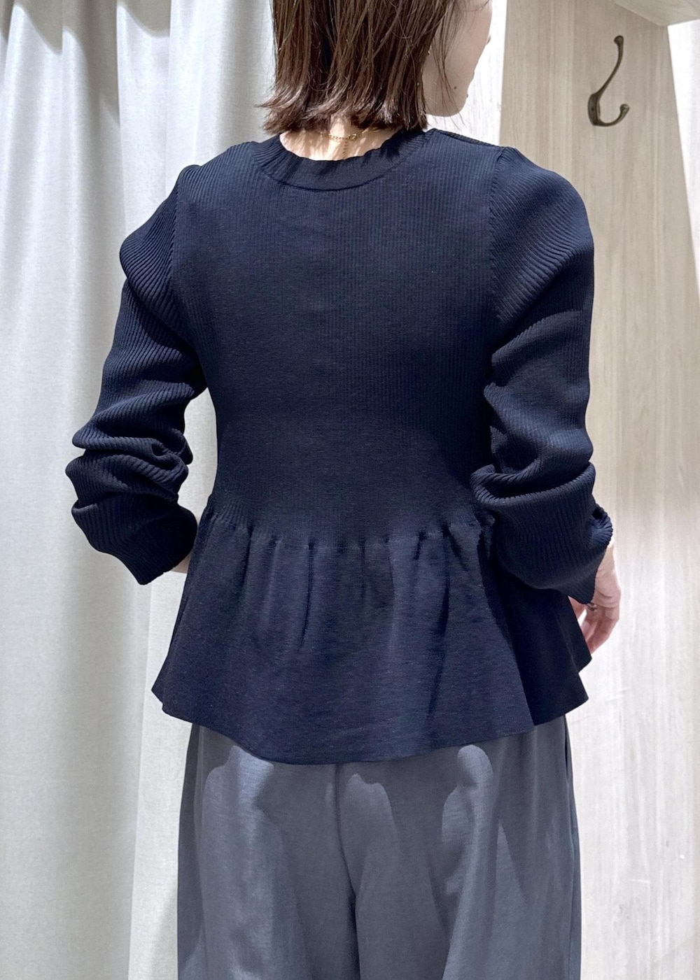 ブラック系のパンプス、グレー系のその他パンツ、ブルー系のカーディガン/ボレロを着用したレディースの冬コーディネートの7枚目の写真