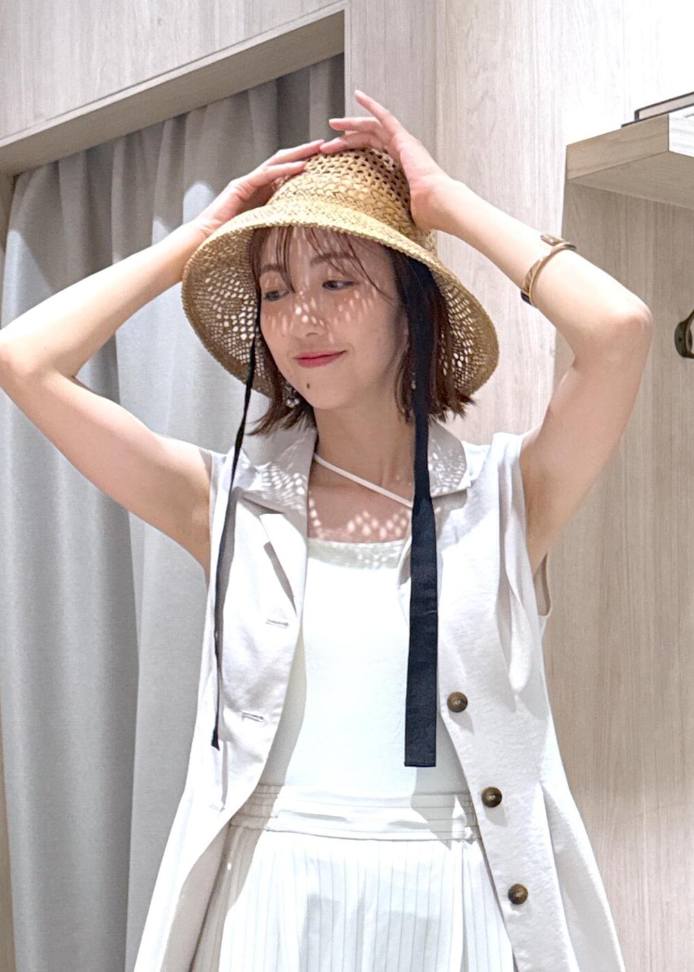 ホワイト系のキャミソール、ブラック系のサンダル、ホワイト系のワンピースを着用したレディースの夏コーディネートの10枚目の写真