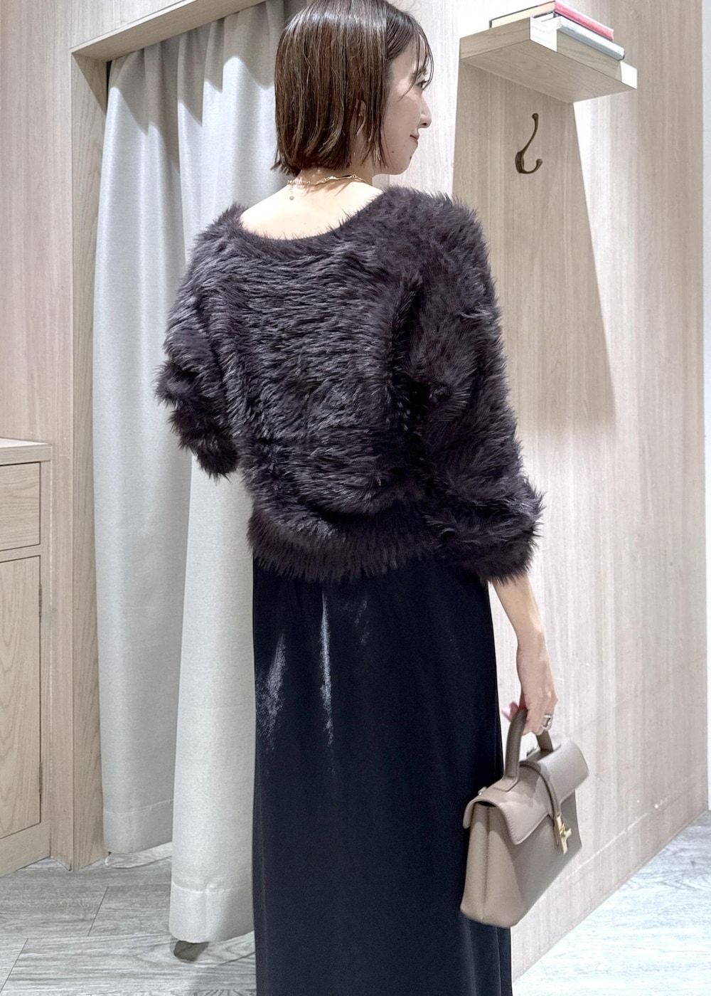 ベージュ系のショルダーバッグ、グレー系のその他アウター、ブラック系のスカートを着用したレディースの冬コーディネートの5枚目の写真