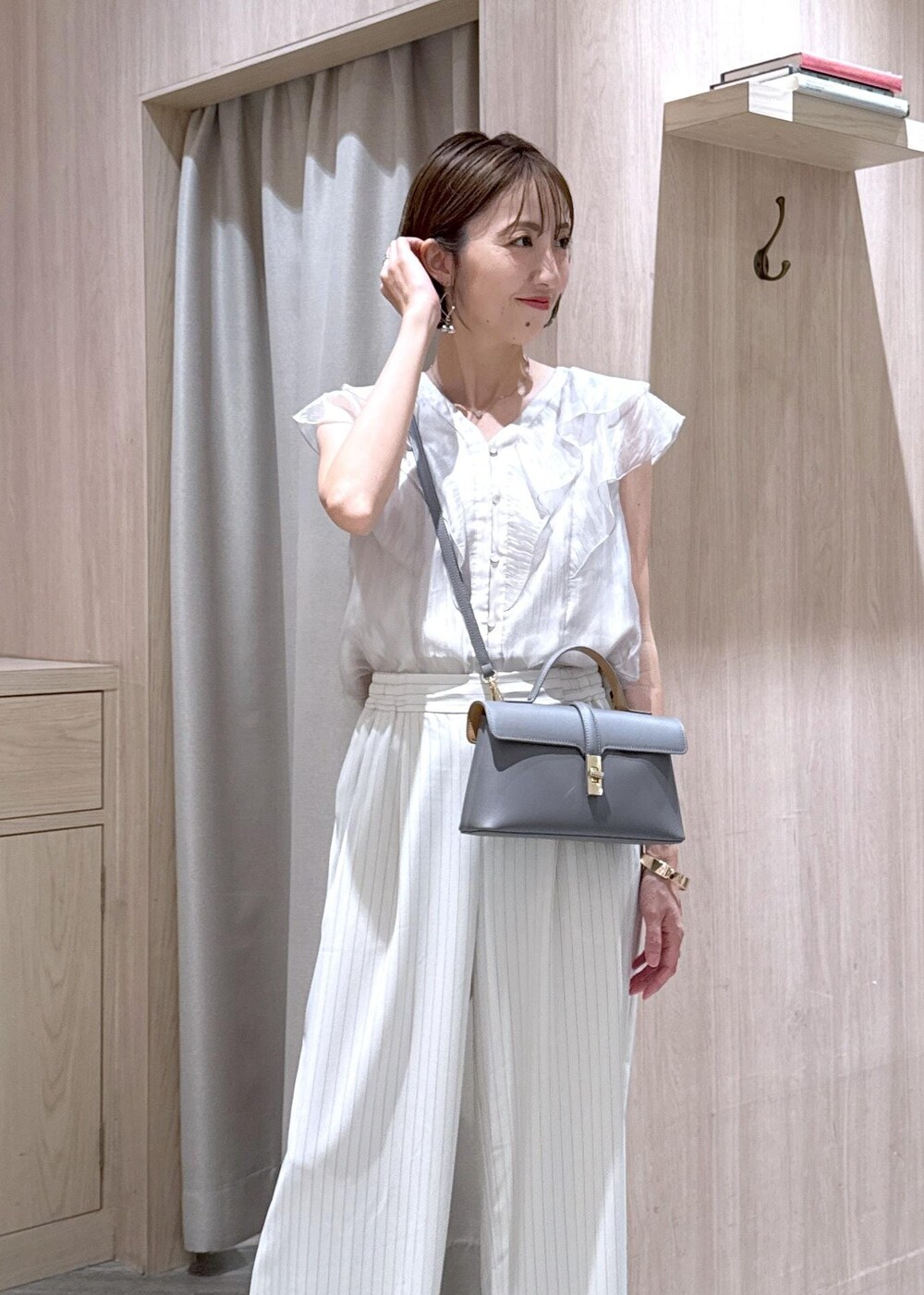 グレー系のショルダーバッグ、シルバー系のパンプス、ベージュ系のシャツ/ブラウスを着用したレディースの夏コーディネートの6枚目の写真