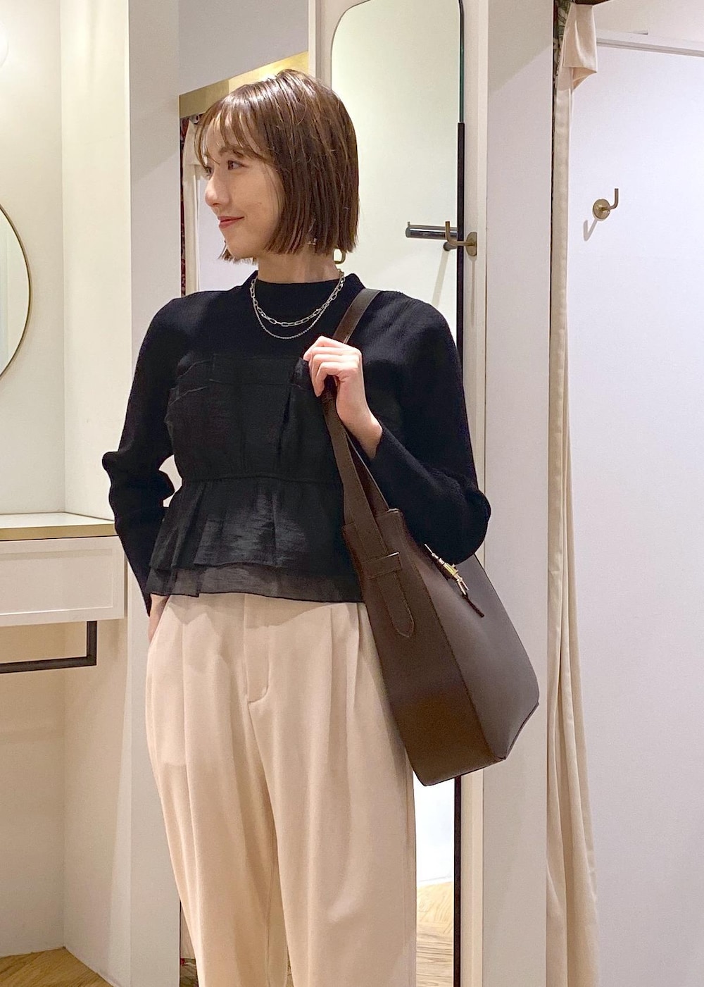 ブラック系のパンプス、ブラック系のニット/セーター、ベージュ系のその他パンツを着用したレディースの冬コーディネートの5枚目の写真