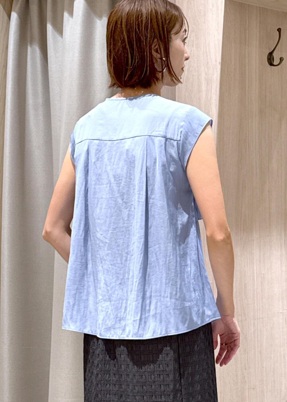 ブラック系のショルダーバッグ、ブラック系のローファー、グレー系のスカートを着用したレディースの夏コーディネートの8枚目の写真