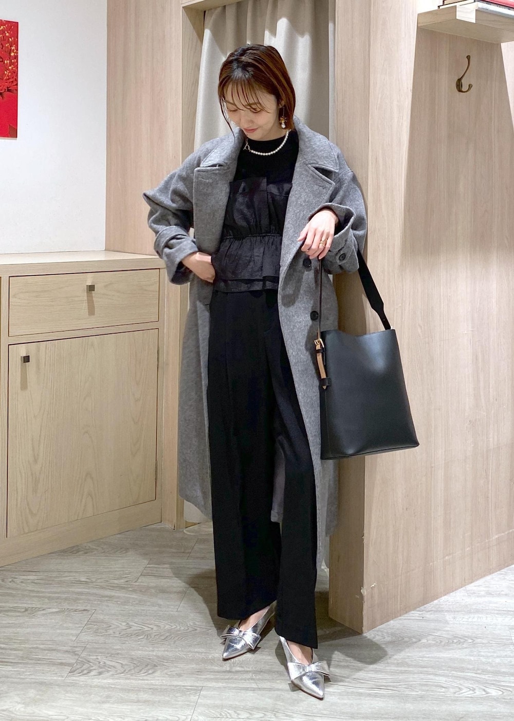 シルバー系のパンプス、ブラック系のスラックス、ブラック系のニット/セーターを着用したレディースの冬コーディネートの3枚目の写真