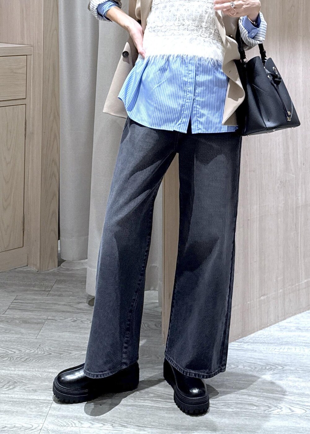 ブラック系のショルダーバッグ、ベージュ系のテーラードジャケット、ブラック系のブーツを着用したレディースの秋コーディネートの5枚目の写真