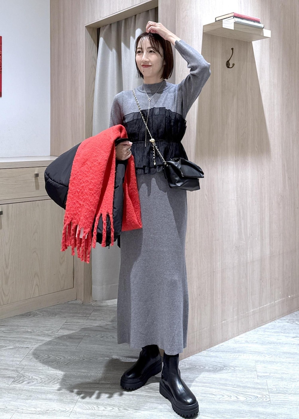 ブラック系のブーツ、ブラック系のダウンジャケット/コート、グレー系のスカートを着用したレディースの冬コーディネートの9枚目の写真