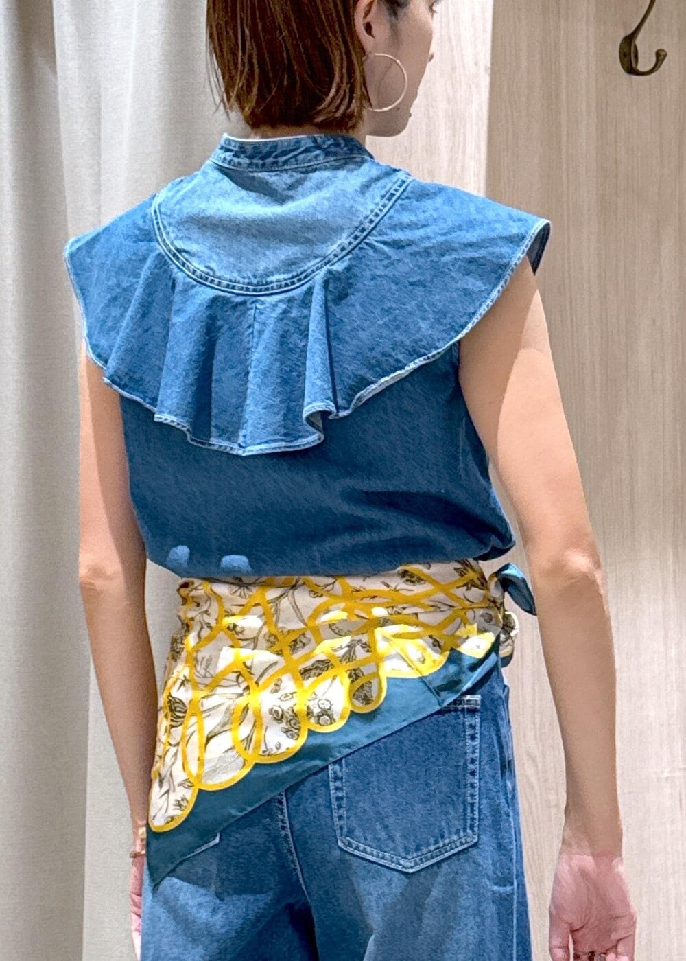 シルバー系のハンドバッグ、ブルー系のシャツ/ブラウス、ブルー系のデニムパンツを着用したレディースの夏コーディネートの9枚目の写真