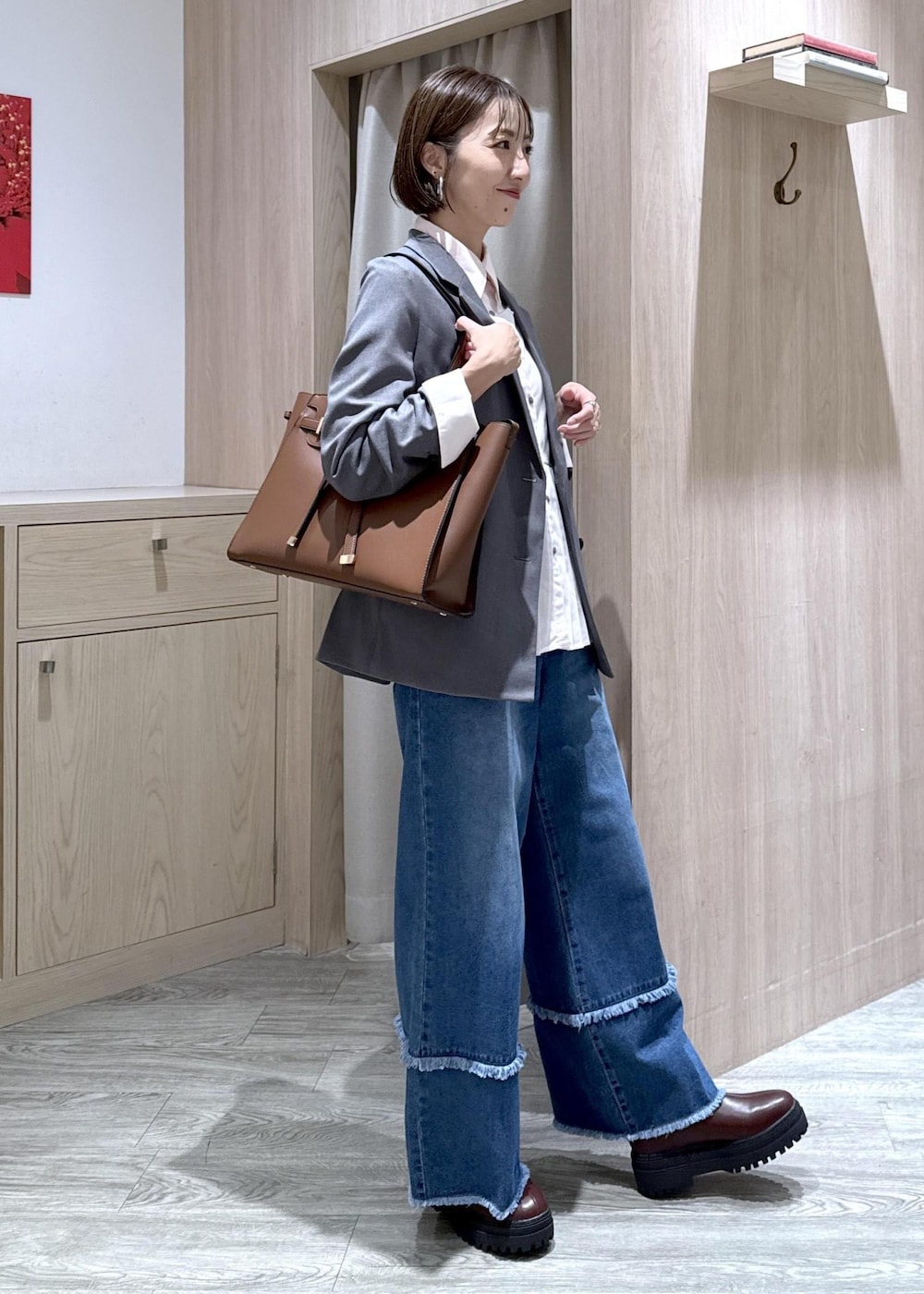 ブラウン系のブーツ、ピンク系のシャツ/ブラウス、ブルー系のデニムパンツを着用したレディースの秋コーディネートの5枚目の写真