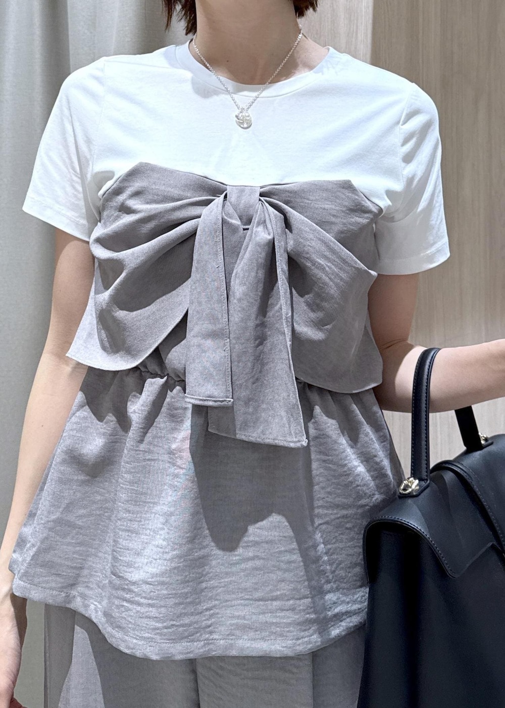 ブラック系のハンドバッグ、ブラック系のパンプス、グレー系のTシャツ/カットソーを着用したレディースの春コーディネートの8枚目の写真