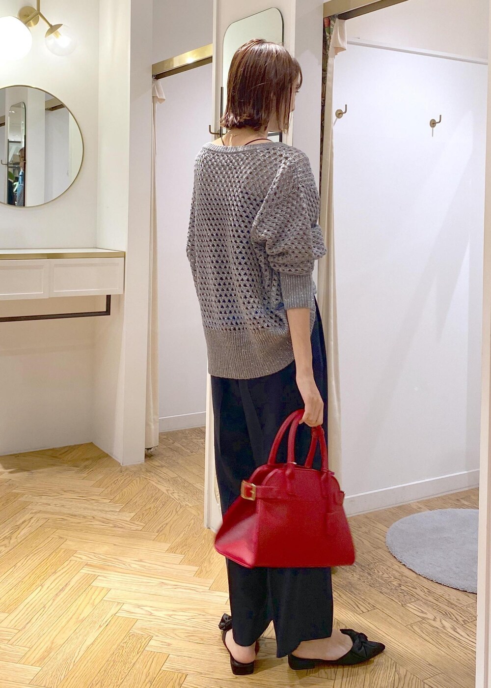 ブルー系のスラックス、ブラック系のサンダル、グレー系のニット/セーターを着用したレディースの秋コーディネートの2枚目の写真