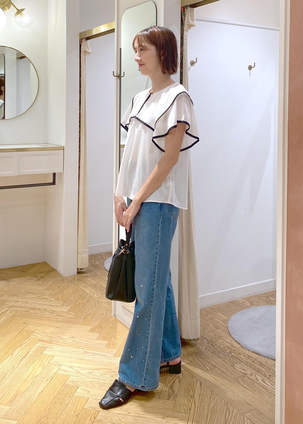 ブラック系のサンダル、ホワイト系のキャミソール、ブルー系のデニムパンツを着用したレディースの夏コーディネートの2枚目の写真