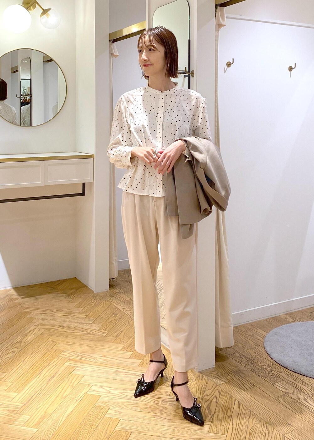 ブラック系のパンプス、ホワイト系のシャツ/ブラウス、ベージュ系のその他パンツを着用したレディースの冬コーディネートの9枚目の写真