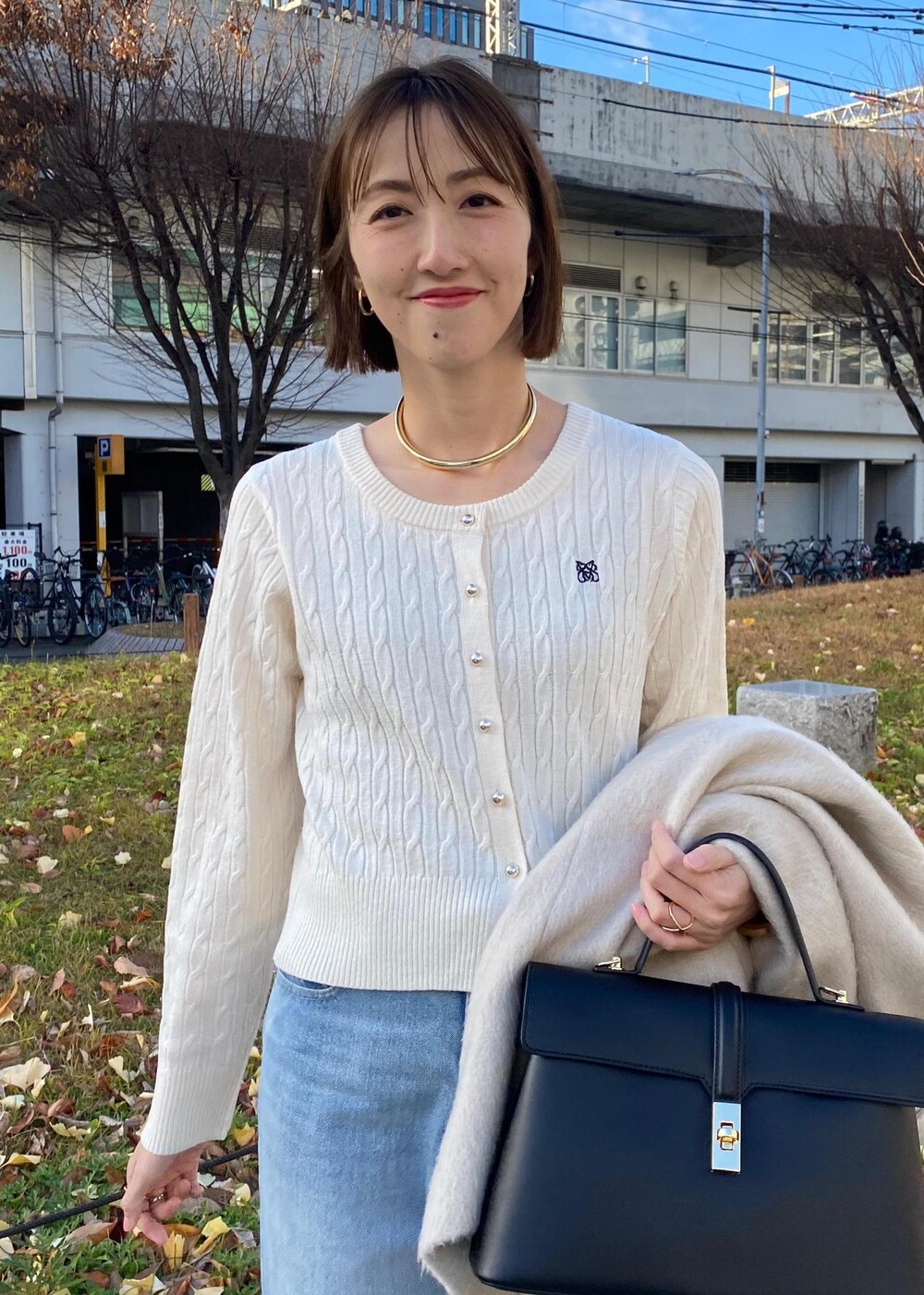 ブラック系のパンプス、ホワイト系のカーディガン/ボレロ、ベージュ系のその他アウターを着用したレディースの冬コーディネートの7枚目の写真